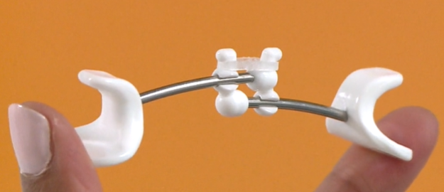 Close up image of a Facial Flex showing how the flex band is hooked onto the device